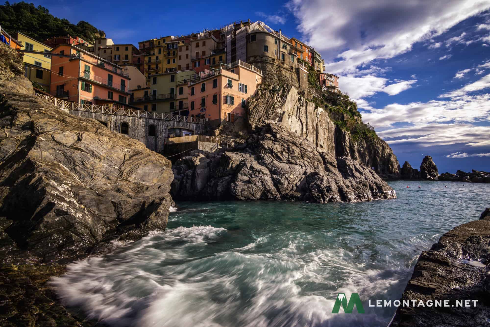 Manarola viewed from the dock area with the waves rushing by.